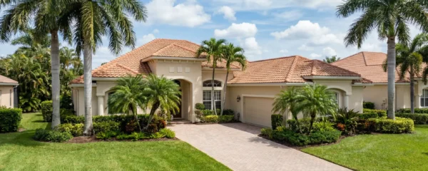 Maison individuelle typique Floride avec palmiers et ciel bleu, investissement locatif